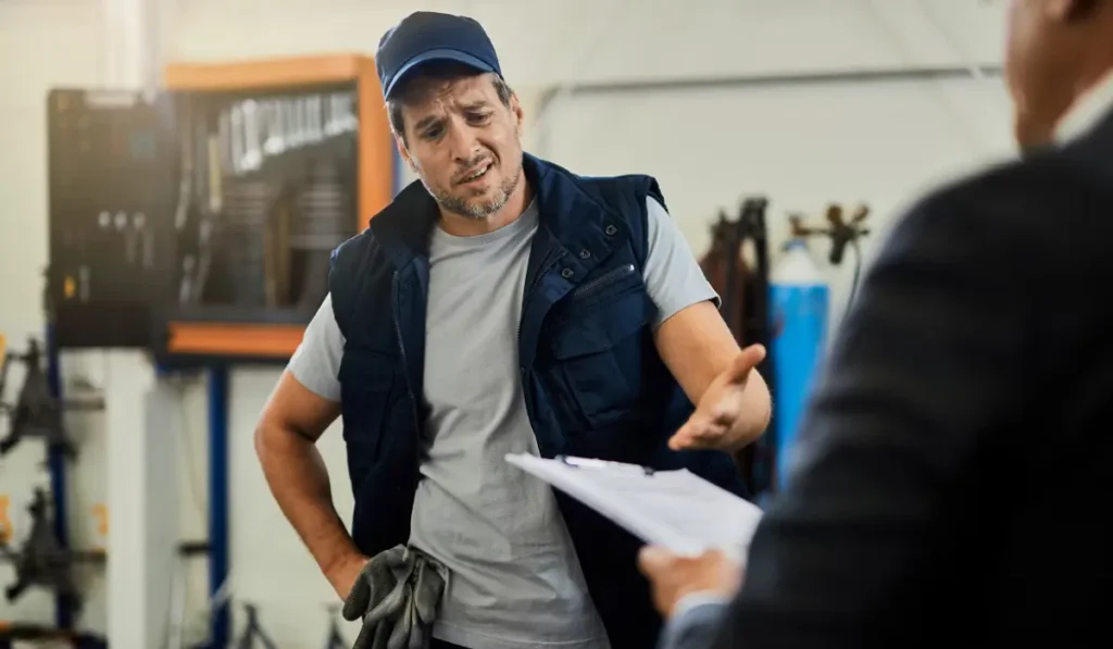dishonest mechanic explaining to customer high prices